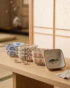Japanese Ceramic Square Sauce Dishes, Set of 4 — low three-quarter angle in a zen interior with soft shoji light