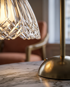 Cordless Crystal-Cut Shade LED Table Lamp, Gold — macro detail of crystal faceted shade and base, luxe interior backdrop, warm side lighting catching the facets
