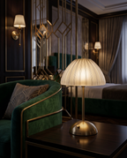Cordless Crystal-Cut Shade LED Table Lamp, Gold — evening mood shot beside a plush armchair, Art Deco boutique hotel suite with brass and velvet accents, intimate ambient glow