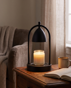 Wood and Glass Candle Warmer Lamp, Timer — mood shot on a nightstand by a reading nook at dusk, soft warm glow onto the candle