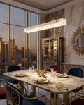 Marble Linear Pendant Light, Gold Wedge LED — hanging over a dining table, modern luxury Art Deco apartment, soft warm light pooling below