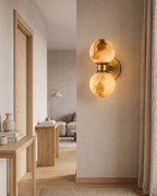 Marble Dual-Globe Wall Lamp, Gold Finish — on a living room hallway wall