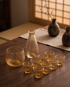 Glass Sake and Bar Serving Set, 6-Piece — full set laid out to show scale, carafe and matching glasses on dark wood
