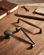 Antique Bronze Cabinet Handles and Knob, Zinc Alloy — set of handles arranged on a warm wooden surface showing scale and finish