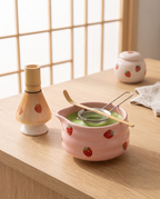 Strawberry Motif Matcha Tea Set, Ceramic and Bamboo — pink ceramic bowl and bamboo whisk, zen Japanese tea corner, hero arrangement on pale oak
