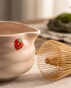 Strawberry Motif Matcha Tea Set, Ceramic and Bamboo — macro detail, pink ceramic glaze and bamboo whisk tines, warm side light