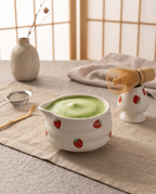 Strawberry Motif Matcha Tea Set, Ceramic and Bamboo — whisked green matcha in pink bowl, linen runner, serene tea corner mood