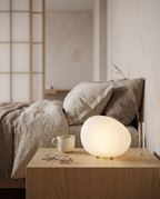 Pebble-Shaped LED Bedside Night Light — scale next to mug, glasses and vase on nightstand
