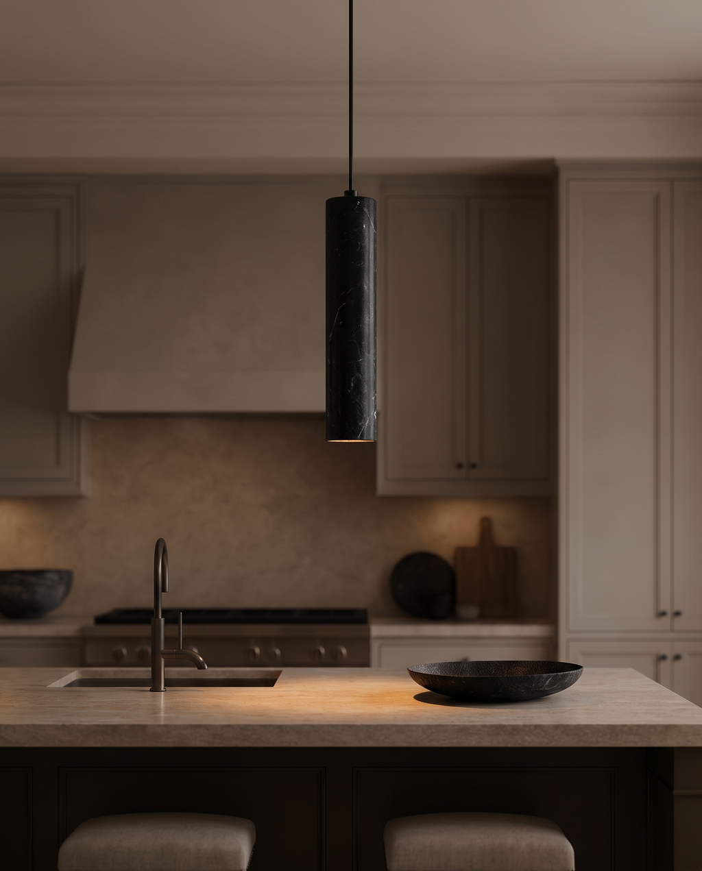 Black Stone Cylinder Pendant Light, Natural Stone — over a kitchen island, modern luxury home, warm glow on countertop