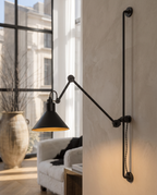 Black Iron Swing Arm Wall Light, Adjustable — alternate angle showing swing-arm articulation, warm neutral wall, adjustable black iron arm