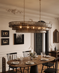 Gray Glass Oval Chandelier, Stainless Steel — hero over a dining table, elegant Parisian apartment, ornate moulding and warm evening glow