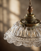 Walnut and Brass Pendant Light, Frosted Glass — detail macro, warm side light on textured glass shade and aged brass base
