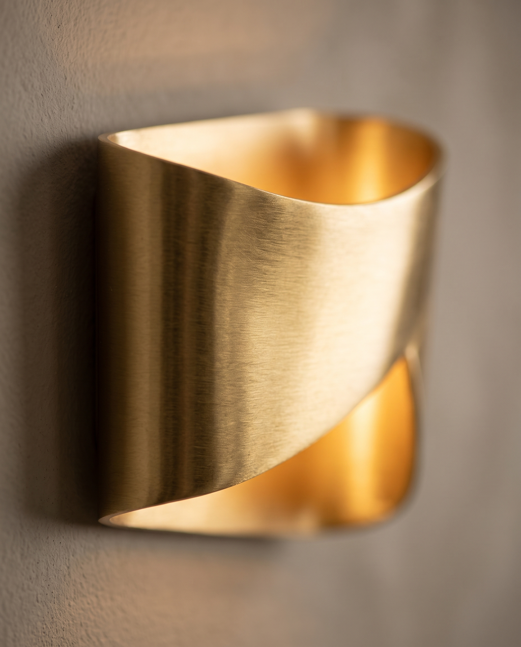 Curved Gold Up and Down Wall Light, Aluminum — macro detail, warm neutral wall, brushed gold finish