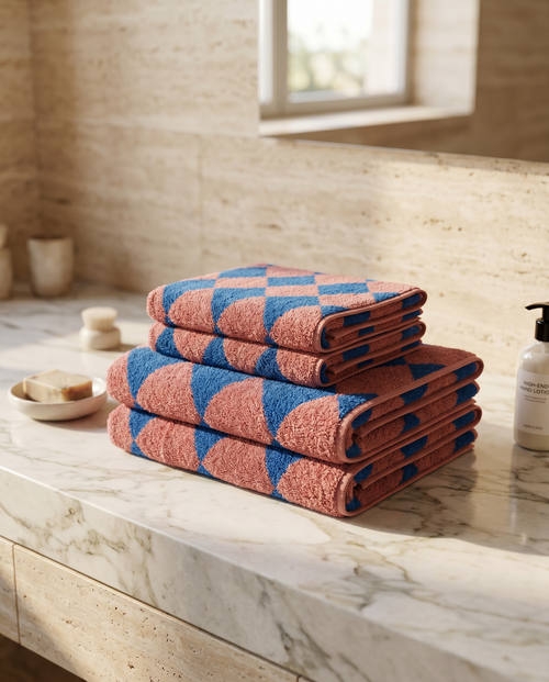 Blue Diamond Pattern Cotton Bath Towel Set — folded stack, marble spa bathroom counter, warm morning light