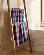 Blue Diamond Pattern Cotton Bath Towel Set — hung over wooden towel ladder with natural folds, spa bathroom, marble