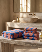 Blue Diamond Pattern Cotton Bath Towel Set — full set bath and hand towels folded together, luxury hotel spa, marble bench