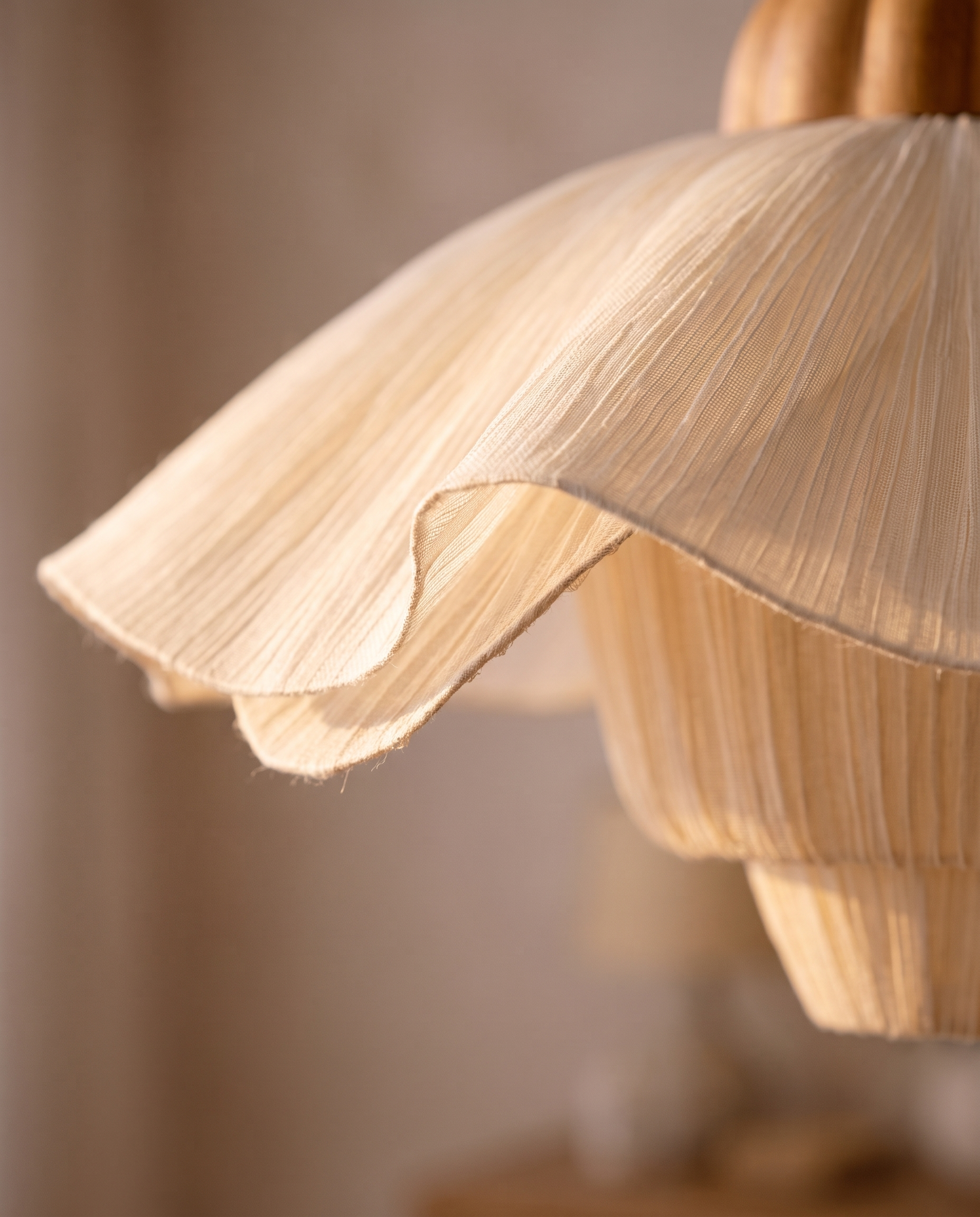 Pleated Petal Fabric Pendant Light, Cream — macro detail of the petal shade, warm side light grazing the translucent layers