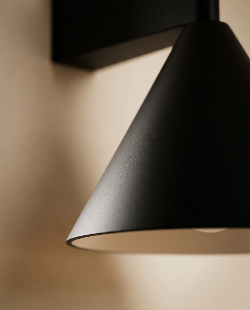 Black Cone Up and Down Wall Sconce, Aluminum — macro detail, warm wall, matte black finish texture