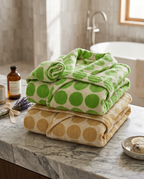 Dotted Jacquard Organic Cotton Bathrobe — folded spa stack showing both colours, marble counter