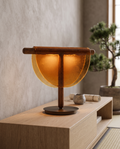 Half-Moon Amber Glass Table Lamp, LED — Amber hero on light-oak console, serene Japandi living room