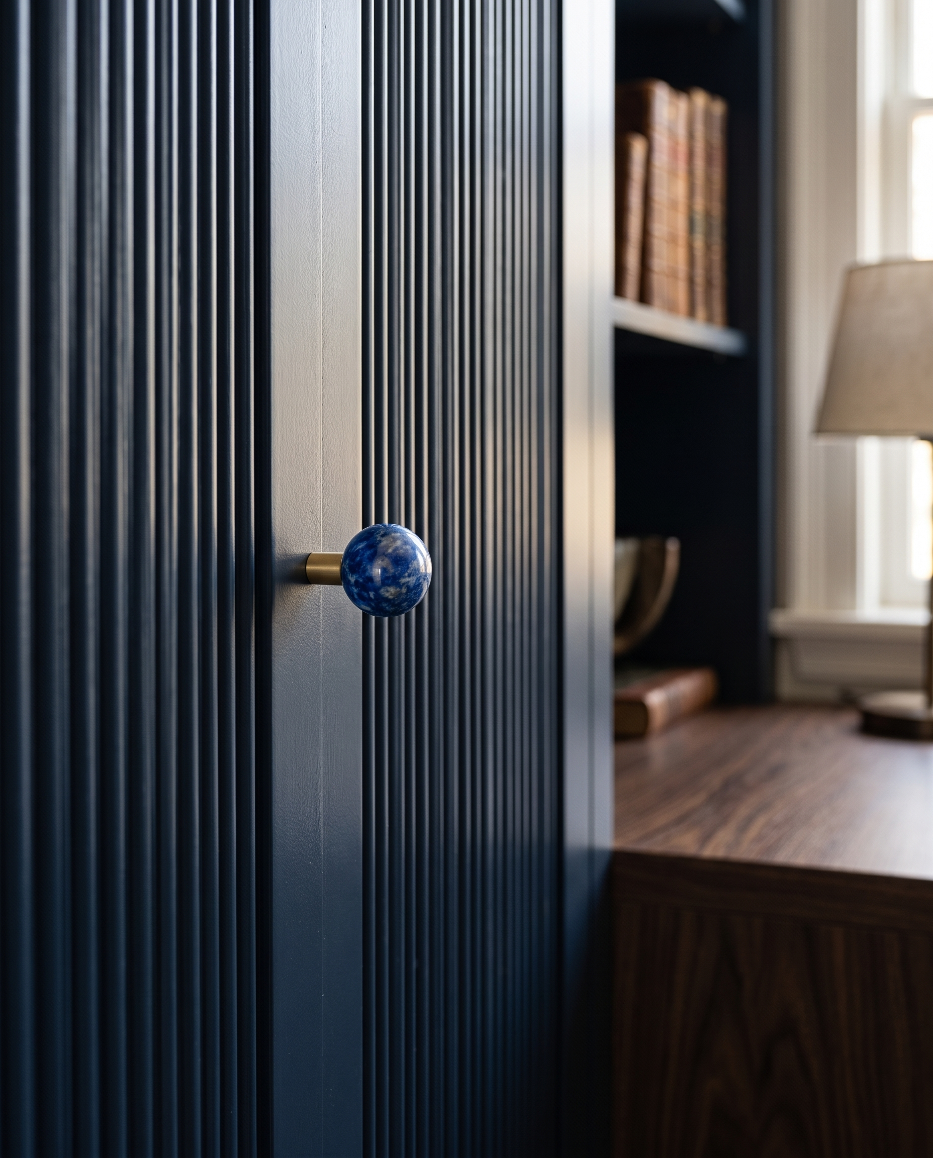 BlushStone Marble Brass Knob — Blue marble knob, mounted on a deep navy fluted cabinet door in a sophisticated study