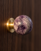BlushStone Marble Brass Knob — macro detail of marble veining and satin brass base, warm side light on an elegant cabinet