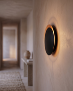 Round Moon Eclipse LED Wall Sconce, Copper — Black & Copper, mounted on hallway wall with soft ambient glow