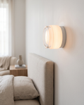 Minimalist Linear LED Wall Sconce, Aluminum and Iron — White, mounted on a serene modern bedroom wall