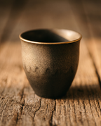 Handmade Stoneware Cup Set, Gold-Rimmed Ceramic — macro detail of glaze and gold accent rim, rustic farmhouse table in warm side light