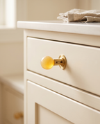 Brass and Crystal Cabinet Knob, Faceted — Yellow crystal, installed on cream Shaker kitchen cabinet drawer