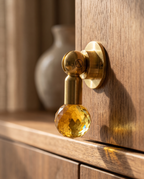 Brass and Crystal Cabinet Knob, Faceted — macro detail of faceted crystal and polished brass base, mounted on cabinet edge