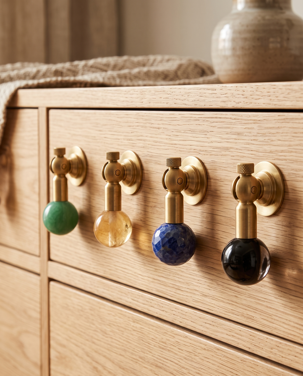 Brass and Crystal Cabinet Knob, Faceted — group of colourways (yellow, black, green, blue) mounted on light wood cabinet drawers