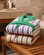 Yarn-Dyed Stripe Organic Cotton Bathrobe — folded spa stack of both colours, warm luxury hotel bathroom