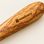 Close-up of the olive grain and branded Maudestry mark