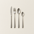 A single place setting: knife, fork, spoon and teaspoon